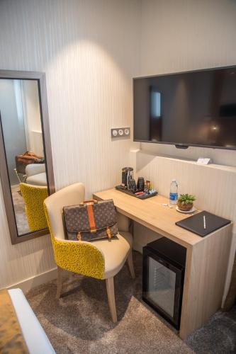 a room with a desk with a chair and a mirror at Best Western Beauséjour in Lourdes
