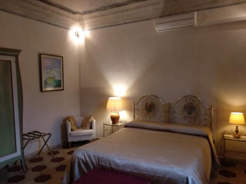 サン・ジュリアーノ・テルメにあるB&B Cribòのベッドルーム(ベッド1台、椅子、ランプ付)