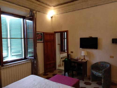a bedroom with a bed and a desk and a television at B&B Cribò in San Giuliano Terme