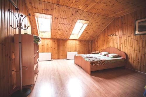 ゼリョンナヤ・ポリャナにあるApartments on Kurortnaya 33の木製の壁のベッドルーム1室(ベッド1台付)
