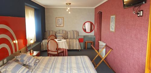 una habitación con cama y un grupo de sillas en el Hotel Gran International de Villa Gesell