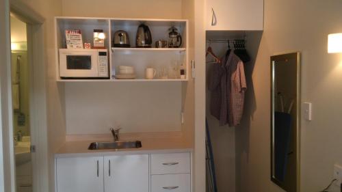 a kitchen with a sink and a microwave at Marineland Beachfront Accommodation in Napier