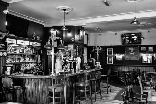 a man standing at a bar in a restaurant at The Ship Inn in London