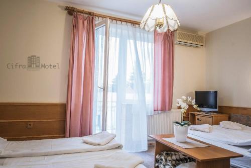 Habitación de hotel con 2 camas y ventana en Cifra Motel, en Kecskemét