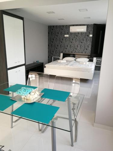 a bedroom with a bed and a glass table at AQUA SOLAR APARTMANHÁZ in Miskolc