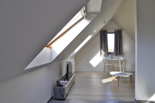 a room with a staircase with a tv and a table at Woestyne Business & Leisure Apartments Cleythil in Aalter