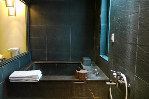 a bathroom with a sink and a bath tub at Shan-Yue Hotspring Hotel in Taipei