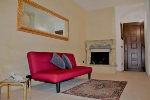 sala de estar con silla roja y espejo en Dimora Porta Nuova, en Galatina