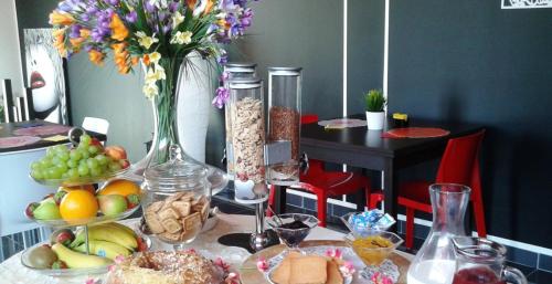 une table recouverte de assiettes de nourriture et d'un vase de fleurs dans l'établissement B&B La Suite Alba Adriatica, à Alba Adriatica