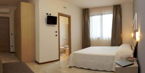 una camera d'albergo con letto e finestra di B&B La Suite Alba Adriatica ad Alba Adriatica