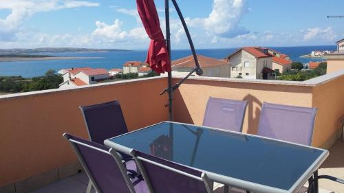 una mesa y sillas en un balcón con vistas al agua en Apartment Pepi, en Povljana