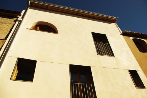 a white building with windows on the side of it at Can Girmas Casa de Turisme rural Navata in Navata