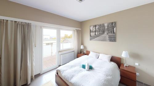 a bedroom with a bed and a large window at 2 Bedroom Penthouse in Gasperich in Luxembourg