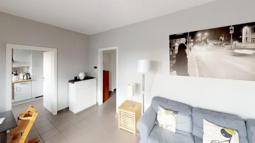 ein Wohnzimmer mit einem Sofa und einem Bild an der Wand in der Unterkunft 2 Bedroom Penthouse in Gasperich in Luxemburg (Stadt)