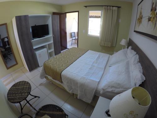 a bedroom with a bed and a television in it at Pousada Porto das Dunas in Aquiraz