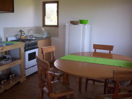 a kitchen with a table and a white refrigerator at cabañas sector peñuelas in Coquimbo