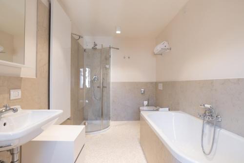 a bathroom with a tub and a sink and a shower at Palazzo Vendramin Costa in Venice