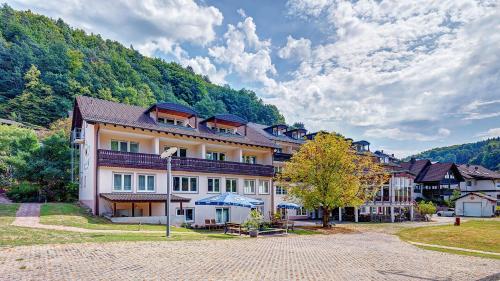 un grand bâtiment au milieu d'une montagne dans l'établissement Hotel Christel, à Heimbuchenthal