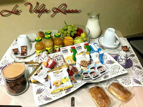 Ein Tisch mit einem Haufen Essen und Getränken drauf. in der Unterkunft Bed and Breakfast La Volpe Rossa in Regalbuto