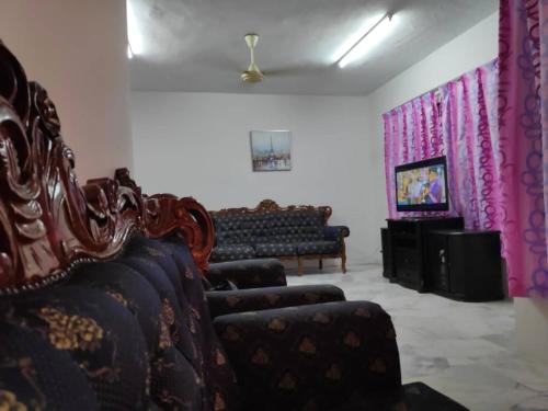 a living room with two chairs and a couch at Homestay PD in Port Dickson