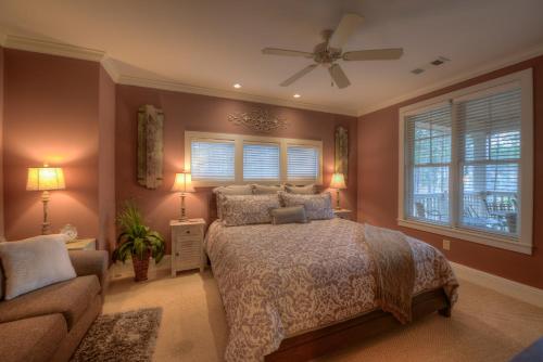 a bedroom with a bed and a couch and windows at The Village Condo in Greensboro