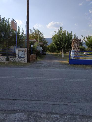 an empty street with a fence and a building at Holiday Tolofona Beach in Eratini