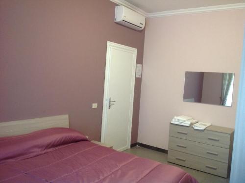 Schlafzimmer mit einem Bett, einer Kommode und einem Spiegel in der Unterkunft A casa di Armando in Rom