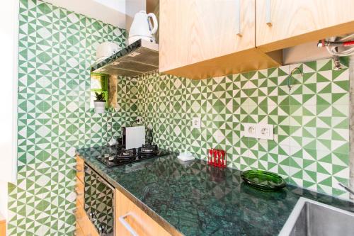 リスボンにあるAlfama Historical Apartmentの緑と白のタイル張りの壁のキッチン