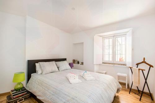 ein Schlafzimmer mit einem Bett mit zwei Handtüchern darauf in der Unterkunft Alfama Historical Apartment in Lissabon