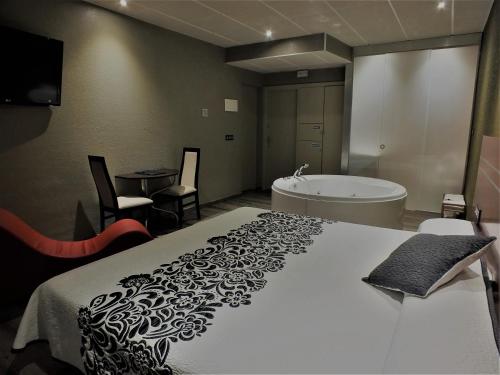 a bedroom with a bed and a bath tub at Motel Los Abedules in Oviedo
