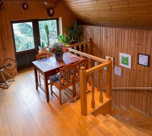 a dining room with a table and stairs in a cabin at Agroturystyka Lolkowo in Srokowo