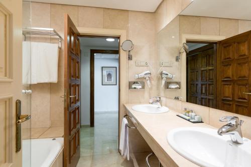 a bathroom with two sinks and a large mirror at Parador de Cordoba in Córdoba