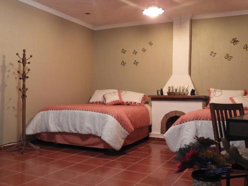 a bedroom with two beds and a fireplace at Casa del Temezcuitate in Guanajuato