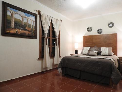 a bedroom with a large bed and a window at Casa del Temezcuitate in Guanajuato