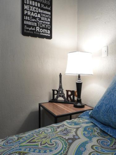 a bed with a lamp on a nightstand next to a bed at Casa del Temezcuitate in Guanajuato