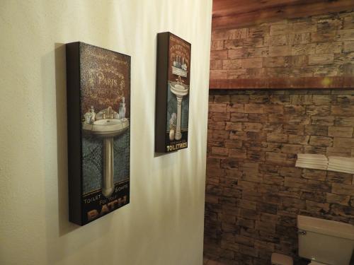 two posters on the wall of a bathroom with a sink at Casa del Temezcuitate in Guanajuato