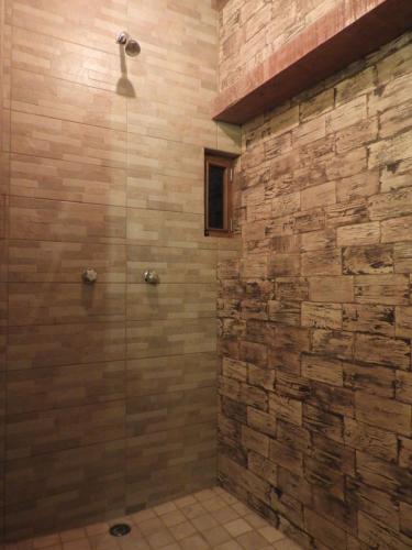 a bathroom with a shower with a stone wall at Casa del Temezcuitate in Guanajuato