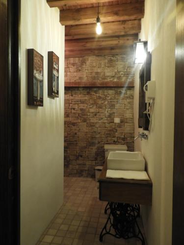 a bathroom with two sinks and a brick wall at Casa del Temezcuitate in Guanajuato