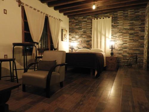a bedroom with a bed and a chair in a room at Casa del Temezcuitate in Guanajuato