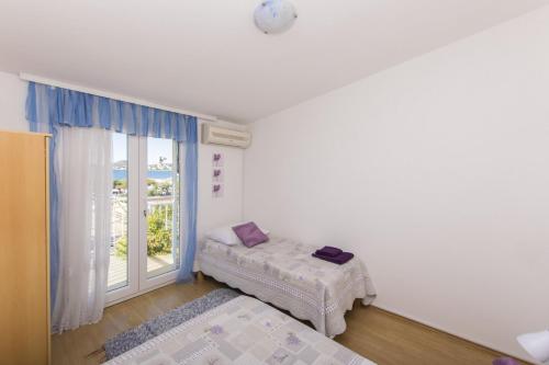 a small room with a bed and a window at Apartment Nediljka in Vodice