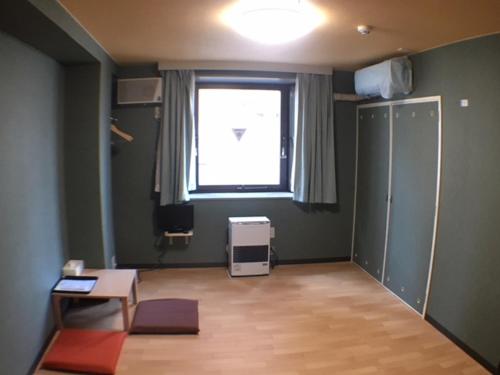 a living room with a room with a window and a table at Asano Hotel in Sapporo