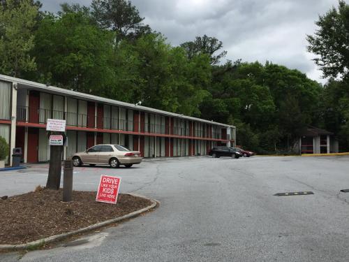ein Gebäude mit einem davor geparkt in der Unterkunft Cheshire Motor Inn in Atlanta