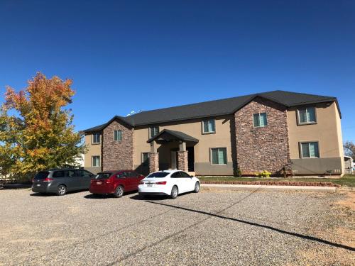 a house with two cars parked in a parking lot at Cedar Canyon Condos in Blanding