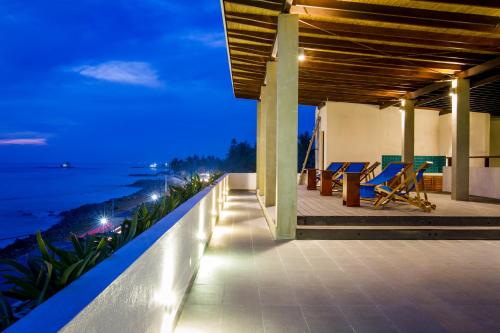 a view of the ocean from a balcony at night at Lazy Koala in Hikkaduwa
