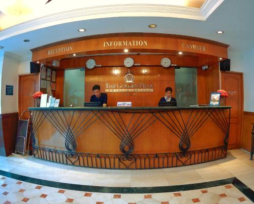two people sitting at a bar in a lobby at Golden Peak Hotel & Suites powered by Cocotel in Cebu City