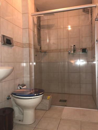 a bathroom with a toilet with a glass shower at Apto continente Florianópolis in Florianópolis