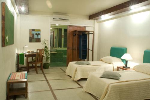 a hotel room with two beds and a bathroom at Punta Bulata White Beach Resort & Spa in Sipalay