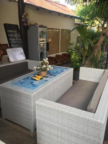 two wicker chairs and a table on a patio at BBS Homestay in Nusa Lembongan