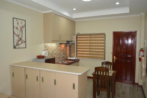 a kitchen with a counter and some chairs in a room at Red Apartelle in Talisay