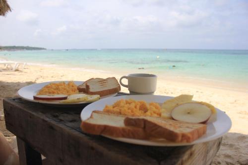 a plate of food on a table on the beach at Pura Vida Baru - La Casa del Cholo in Barú